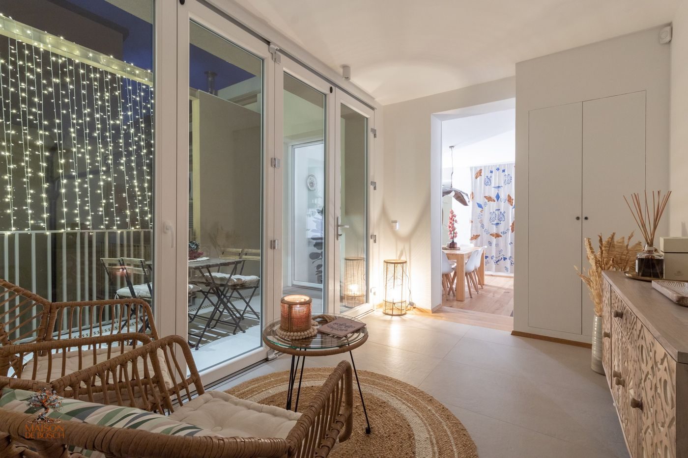 Veranda di Maison De Bosch la sera, con poltrone e luci accese